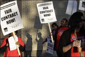 Chicago teachers walk a picket line outside Benjamin Banneker Elementary School in Chicago, early Monday.