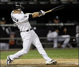 Chicago White Sox's Gordon Beckham hits a two-run home run off Detroit Tigers relief pitcher Phil Coke, also scoring Alexei Ramirez, during the eighth inning of a baseball game.