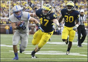University of Michigan players Jake Ryan (47) and Thomas Gordon (30) can't keep up with Air Force's Cody Getz as he heads for the end zone to score in the fourth quarter on Saturday.
