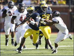 Michigan's Denard Robinson streaks past Randall Jette and the rest of the University of Massachusetts defense. Robinson racked up 397 yards for the Wolverines.