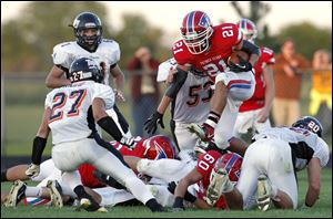 Patrick Henry tail back Tobey Hernandez runs the ball against Liberty Center defensive back Anthony Righi (27).