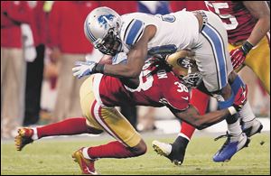 Detroit Lions running back Kevin Smith, top,  is upended by San Francisco 49ers free safety Dashon Goldson during the third quarter Sunday  in San Francisco. The Lions lost 27-19.
