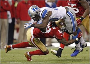 Lions safety John Wendling goes airborne to pull down San Francisco's Kendall Hunter in Sunday night's game. Detroit had a chance to take over the lead in the NFC North but was soundly beaten.