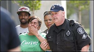 Police escort a woman identified as the mother of Klein Michael Thaxton, into 3 Gateway Center this morning. Police say Thaxton is the the man holding a hostage on the 16th floor of Number 3 Gateway Center.