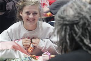 Mallory Gremler, a sophomore, opens the bag of carrots that are a part of her school lunch as she talks with USDA Food and Nutrition Service Administrator Audrey Rowe.
