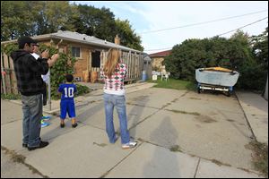 People photograph the driveway in Roseville, Mich. on Wednesday, where police plan to take soil samples f Friday after a tipster said it could be the final resting place of missing Teamsters leader Jimmy Hoffa. 
