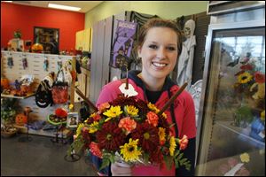 Floral Design and Greenhouse Production program student Abby Lutes, 17, of Walbridge, holds an arrangement she created for Thursday's Fall Harvest Sale at Penta Career Center in Perrysburg Township.