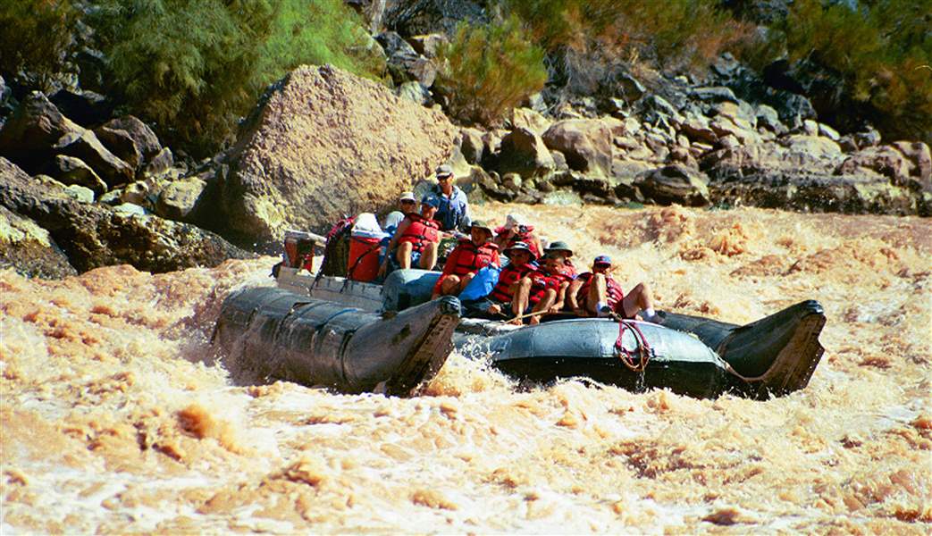 Visitors-ride-a-pontoon-raft-through-rapids