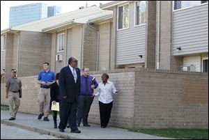 Douglas Shelby, HUD field office director in Cleveland, front, left, tours of the Greenbelt Place apartments in Toledo, with residents and apartment management, including Ryan Agge, second from right.