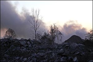 A fire smolders at the Stickney Recycling plant on 4425 Creekside Drive in Toledo on Thursday.