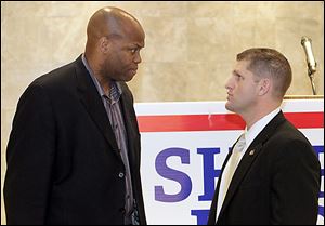 Michelle Obama's brother Craig Robinson, left, who is also the men's basketball coach at Oregon State, talks to Ohio House Rep. Matthew Szollosi.
