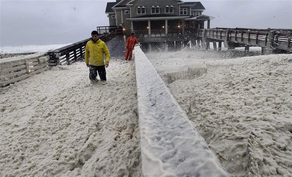 A-news-crew-wades-through-sea-foam-blown