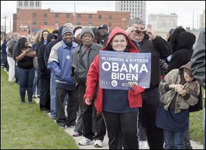Solana Lopez, 12, holding sign, her brother Jesse, 10 and their dad Scott Lopez, all of Pemberville, wait in line to see the president. People line up to enter Lima Senior High School before a visit from Pres. Barak Obama.