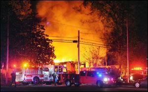 Flames and smoke billow from a home in west Jackson, Miss., Tuesday evening after authorities say a small plane carrying three people crashed into the residence shortly after 5 p.m. 