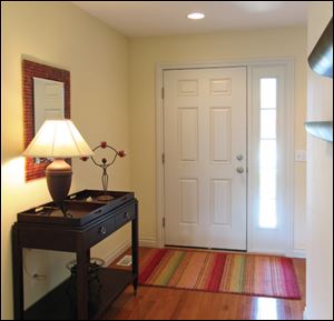 The model home's wide foyer welcomes visitors with beautiful oak hardwood floors.