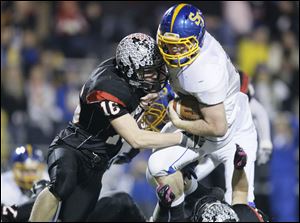 McComb High School player Mitch Schroder ,16, hits Delphos St. John's player Tyler Jettinghoff, 14, during the second half at Donnell Stadium in Findlay.