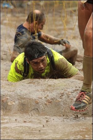 Teammate Dioni Gomez recovers from a 10,000 volt shock that sent him down into the mud.