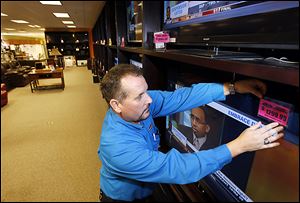 Jeff Podgorski tags televisions at Appliance Center in Maumee in preparation for Black Friday. The store will be closed today.