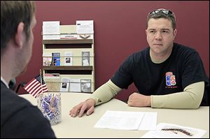 Buck Clay, right, a former U.S. Army staff sergeant who served in Iraq and Kosovo, talks with a fellow veteran in the veterans support center at the University of Cincinnati.  He said veterans, who can have difficulty making the transition from the regimented military culture to a campus environment, need a sense of com­mu­nity and sup­port.