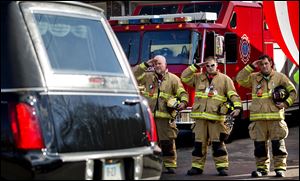 Firefighters salute as a hearse passes for the funeral procession to the burial of 7-year-old Sandy Hook Elementary School shooting victim Daniel Gerard Barden on Wednesday.