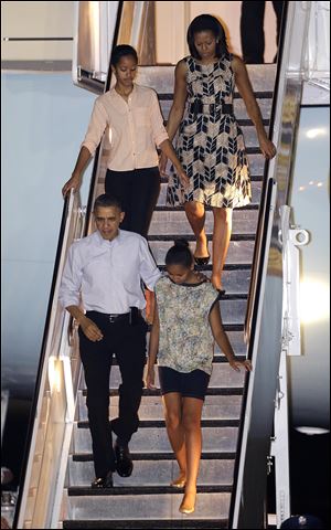 President Barack Obama arrives today with first lady Michelle Obama, top, and daughters Malia, top left, and Sasha, bottom right, at Honolulu Joint Base Pearl Harbor-Hickam in Honolulu, for the start of their holiday vacation.