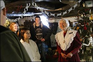 Tour leader Mary Frances Berger  listens to a question from Todd Zielinski  of Maumee, left, as his family tours the Wolcott House Museum. Today is the last day for the Christmas display. 