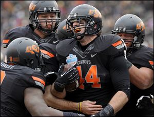 Oklahoma State tight end Jeremy Seaton (44) celebrates with teammates after a first-half touchdown against Purdue during the Heart of Dallas Bowl. Oklahoma State beat Purdue 58-14.