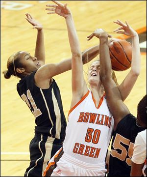 Bowling Green State University's Miriam Justinger gets an arm in the face while being defended by UCF's Kiana Morton, left, and Erika Jones.