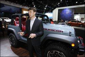 Jeep CEO Mike Manley speaks about the company while standing near a Jeep Wrangler 10th Anniversary Rubicon at the North American International Auto Show in Detroit today.