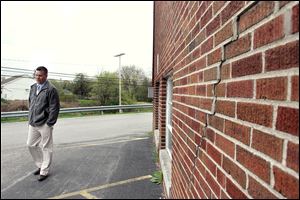 Pat Murtha, Rossford High School vice-principal, walks by cracks in the wall of Rossford High School, which was built in 1922. Bringing the high school up to standards would cost $18 million over 10 years.