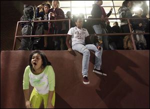 Fans leave the gym after a fight in Scott High School during the Scott v. Rogers basketball game. Two girls in the front react to the spray that was set off in the gym.