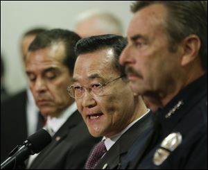 Irvine, Calif., Mayor Steven Choi, center, talks about the $1,000,000 reward for accused killer and fired Los Angeles police officer, Christopher Dorner as Los Angeles Mayor, Antonio Villaraigosa, left, and Los Angeles Police Chief Charlie Beck look on during a new conference at the Los Angeles police department in Los Angeles.