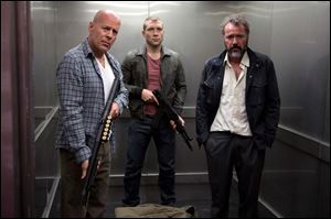 Bruce Willis as John McClane, left, Jai Courtney as his son Jack, center and Sebastian Koch as Komarov in a scene from 