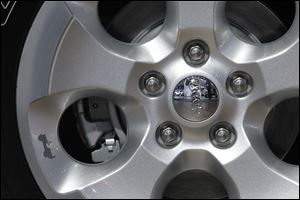 The wheel of a Jeep Wrangler Unlimited Sahara salutes the company's past with a small decal in on the lower left portion of the wheel at the North American International Auto Show in Detroit.