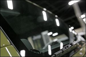 The new Jeep Wrangler includes a small decal of a Jeep on the corner of the windshield (bottom center of image).