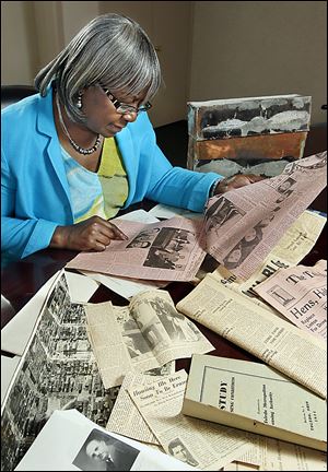 Linnie Willis, executive director of the Lucas Metropolitan Housing Authority, looks at an old newspaper article from a time capsule that was found during the demolition of the Brand Whitlock Homes in Toledo. The copper capsule was found in the summer.