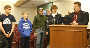 Rich Palmer, far right, reads the citation to members of the Tuite family, including, from left, brothers Matt and TJ, their father, Joseph, and their mother, Dawn. The Tuites received the award from the Ohio Department of Commerce and the Sylvania Township Fire Department on Tuesday.