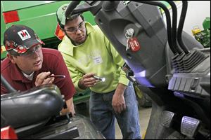 Penta students Marshall Kohl, 18, of Rossford, left, and Tanner Engle, 18, of Bowling Green, right, take a look at a forklift during the 20th annual FAA District I Agricultural and Industrial Diagnostics Contest. The competition pitted teams of two from local high schools against a clock to fix farm machinery.