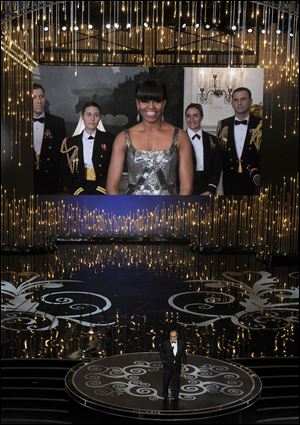 First lady Michelle Obama, appearing on screen, and actor Jack Nicholson present the award for best picture during the Oscars.