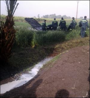 Rescue workers inspect the scene of a balloon crash outside al-Dhabaa village, just west of the city of Luxor, 320 miles south of Cairo, Egypt.
