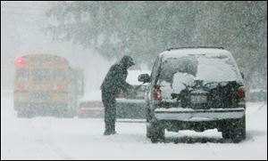 Juan Chavez, of Mundelein, Ill  clears the snow from his car during a snow storm today in Mundelein, Ill.