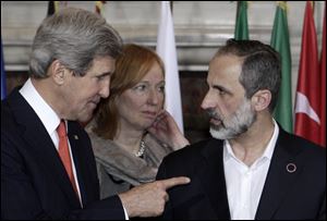 U.S. Secretary of State John Kerry, left, talks to Syrian opposition coalition leader Mouaz al-Khatib, during an international conference on Syria at Villa Madama, Rome, today.