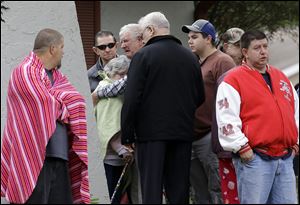 Family members console each other near the home where Jeff Bush disappeared as a large sinkhole opened under the bedroom of his house today in Seffner, Fla. 