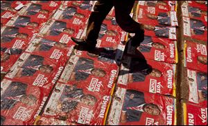 A supporter walks down steps plastered with campaign posters of Kenyan Presidential candidate Uhuru Kenyatta at his campaign's final rally at Uhuru Park in Nairobi, Kenya Saturday.