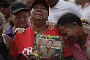 Supporters of Venezuela's President Hugo Chavez cry outside the military hospital where President Hugo Chavez, aged 58, died Tuesday in Caracas.