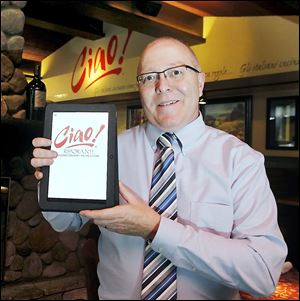 Ciao! Ristorante general manager Terry Kretz holds an Acer tablet menu in use at the restaurant.