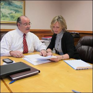 Chuck Mira and Connie Farell look over paperwork at the office of Mira & Kolena on Monroe Ave.