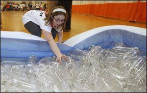 Fourth grader MaKayla Edmond of Indian Hills Elementary School grabs a bottle during a relay Saturday in the 15th annual Wood County Youth Olympics in Bowling Green.