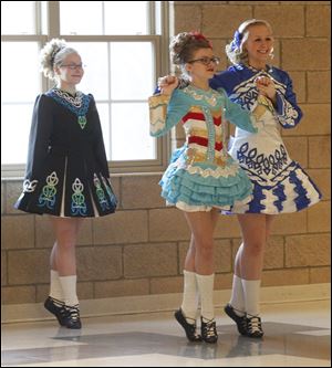 From left, Mary-Catherine Scarett, Maegan Fleniken, and Brenna Kummer of the Ardan Academy of the Irish Dance perform Sunday during a festive night celebrating St. Patrick's Day at St. Joseph East Campus.