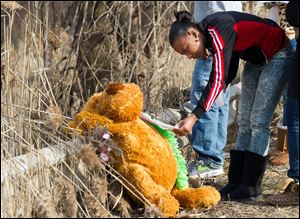 Mindy Morgan reads a note at the memorial where six teens were killed in a car crash on Park Ave. in Warren, Ohio on Sunday.